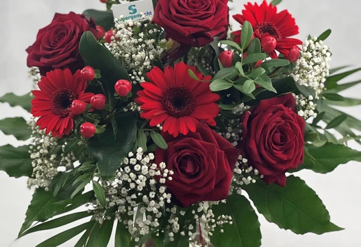 Blumenstrauß Größe M in Rot mit Rosen, Gerbera, Schleierkraut und roten Beeren in einer Vase