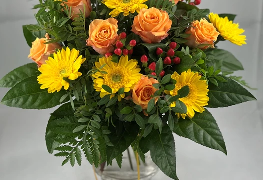Blumenstrauß Größe L in Gelb und Orange mit Gerbera, Rosen und roten Beeren in einer Glasvase