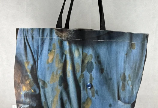 Re-Use Shopper aus Werbebannern in Blautönen mit schwarzen Henkeln, Vorderansicht